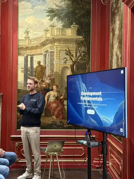 A trainer presenting next to a screen showing the programme