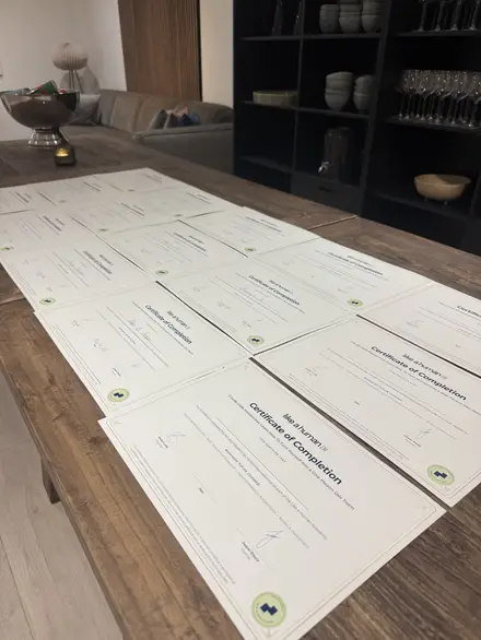 Signed certificates laid out on a wooden table