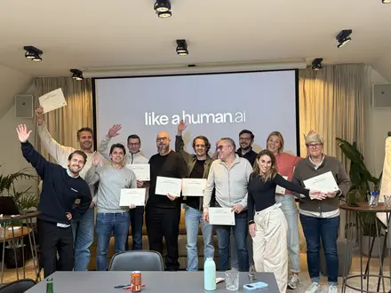 A group waving their certificates in front of the screen